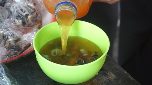 Rujak batu-batu berbahan dasar kerang laut rebus yang diguyur dengan kuah cabai cuka asam pedas di Tanjung Benoa, Kuta Selatan, Badung, Bali. (Foto: Agus Eka/detikBali)