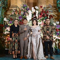 Untuk sesi kedua, Denny dan Bella berganti busana dengan tema modern. Mempelai pria mengenakan setelan jas abu-abu, sementara mempelai wanita tampil glamor berbalut gaun warna silver dan tiara. Foto: Instagram/@showimah