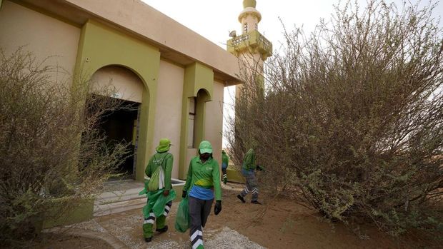 Labourers clean a mosque at the Ghost Village in Al Madam area, 100 km, 62 miles, southeast of Sharjah, United Arab Emirates, Sunday, July 9, 2023. Built-in the 1970s, the village was abandoned two decades later as oil wealth transformed the country into a global hub of commerce and tourism, home to the futuristic cities of Dubai and Abu Dhabi. (AP Photo/Kamran Jebreili)