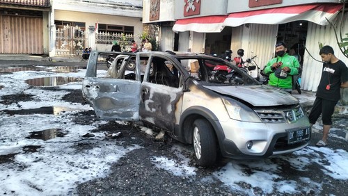 Mobil Nissan Grand Livina silver dengan nomor polisi DK-1996-AI terbakar di area parkir Pusat Perbelanjaan Blok C3, Jalan Thamrin, Pemecutan, Denpasar, Bali, Senin (21/8/2023).(Foto: Dok. Polresta Denpasar)