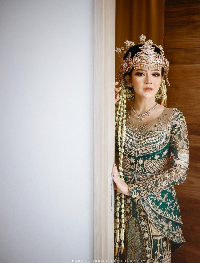 Kebaya Bella Bonita tampak mewah penuh hiasan bordir, payet, kristal serta manik-manik. Ekor panjang menyapu lantai menambah kesan royal pada penampilannya. Foto: Instagram/@faralljibrill_official @denny_caknan