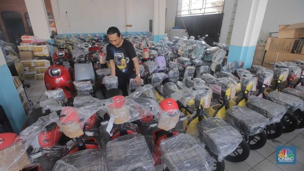 Pekerja merapikan kendaraan motor listrik di salah satu dealer motor listrik, Jakarta, Senin (21/8/2023). (CNBC Indonesia/Muhammad Sabki)