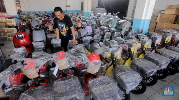 Pekerja merapikan kendaraan motor listrik di salah satu dealer motor listrik, Jakarta, Senin (21/8/2023). (CNBC Indonesia/Muhammad Sabki)