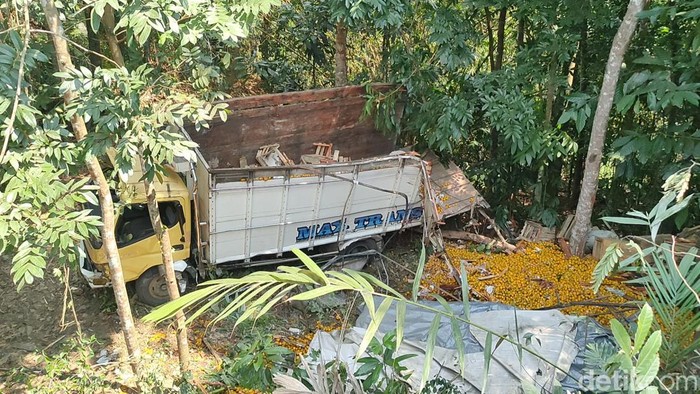 Penampakan truk bermuatan jeruk terguling ke dalam jurang di Kalibawang Kulon Progo, Senin (21/8/2023). Insiden ini menewaskan seorang penumpang truk.