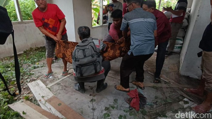 Polisi dan warga saat evakuasi korban gantung diri di rumah kosong di Jambi.