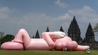 Pengunjung berada di dekat karya seni kontemporer seniman dunia Brian Donnelly atau KAWS saat pameran bertajuk Kaws : Holiday Indonesia di pelataran Candi Brahma di Kompleks Candi Prambanan, Sleman, D.I Yogyakarta, Sabtu (19/8/2023). 