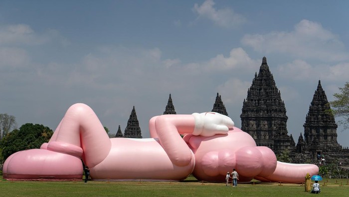 Pengunjung berada di dekat karya seni kontemporer seniman dunia Brian Donnelly atau KAWS saat pameran bertajuk Kaws : Holiday Indonesia di pelataran Candi Brahma di Kompleks Candi Prambanan, Sleman, D.I Yogyakarta, Sabtu (19/8/2023). Pameran yang menampilkan karya instalasi dengan panjang 45 meter dan tinggi mencapai 15 meter tersebut dipamerkan untuk publik mulai 19 hingga 31 Agustus 2023 mendatang. ANTARA FOTO/Andreas Fitri Atmoko/foc.