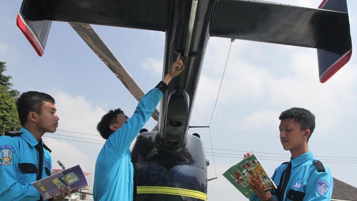 Siswa SMK di Malang pelajari helikopter Siswa jurusan teknik otomotif mempelajari cara kerja dan rangka mesin helikopter ringan jenis NBO 105 di SMK National Media Center (NMC) Malang, Jawa Timur, Senin (21/8/2023). Helikopter yang sebelumnya milik maskapai Pelita Air tersebut kini digunakan sebagai media edukasi bagi siswa guna menambah literasi tentang teknologi mesin penerbangan. ANTARA FOTO/Ari Bowo Sucipto/aww.