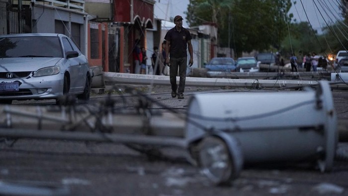 Laura Elizalde Reyes looks at a light pole that hit her car as Tropical Storm Hilary hits Baja California state, in Mexicali, Mexico, August 20, 2023. REUTERS/Victor Medina     TPX IMAGES OF THE DAY