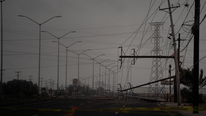 Laura Elizalde Reyes looks at a light pole that hit her car as Tropical Storm Hilary hits Baja California state, in Mexicali, Mexico, August 20, 2023. REUTERS/Victor Medina     TPX IMAGES OF THE DAY