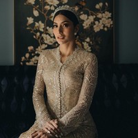 Kebaya berpalet champagne ini dihiasi kristal serta payet dengan aksen kancing depan serta lengan lonceng. Kebaya dipadankan dengan kain songket bernuansa emas. Foto: Instagram/@tyasmirasih @morden.co