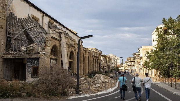 Wartawan berjalan selama tur terorganisir melewati bangunan-bangunan terbengkalai yang runtuh sebagian di Varosha, di daerah berpagar Famagusta, di bagian utara pulau Siprus, Mediterania timur, pada 19 Juni 2023. (Photo by Amir MAKAR / AFP)