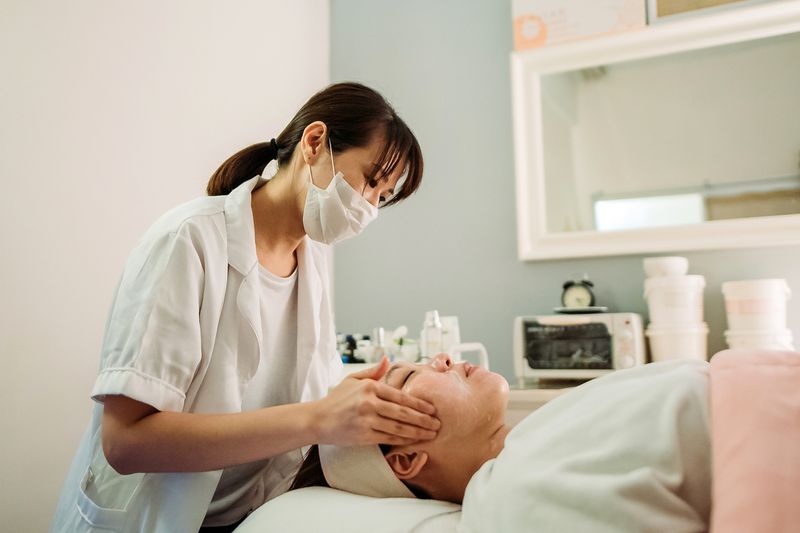 beautician applying mask for female customer