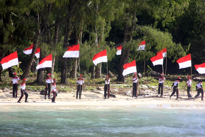 Pelajar mengibarkan dan membentangkan bendera Merah Putih di pulau terluar Pantai Kepulauan Fani Kabupaten Raja Ampat, Papua Barat Daya, Senin (21/8/2023). Pemerintah Provinsi Papua Barat Daya mengajak warga untuk turut mejaga kedaulatan dan mencintai NKRI di wilayah perbatasan tapal batas NKRI dengan negara Palau. ANTARA FOTO/Olha Mulalinda/tom.