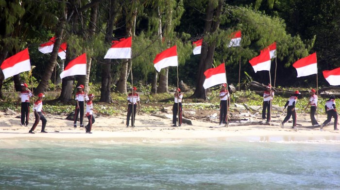Khidmat Pengibaran Merah Putih di Tapal Batas RI-Palau Pelajar mengibarkan dan membentangkan bendera Merah Putih di pulau terluar Pantai Kepulauan Fani Kabupaten Raja Ampat, Papua Barat Daya, Senin (21/8/2023). Pemerintah Provinsi Papua Barat Daya mengajak warga untuk turut mejaga kedaulatan dan mencintai NKRI di wilayah perbatasan tapal batas NKRI dengan negara Palau. ANTARA FOTO/Olha Mulalinda/tom.