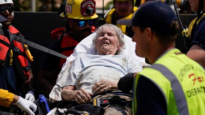 Momen Evakuasi Penghuni Panti Jompo yang Terdampak Badai Hilary Firefighters and emergency medical personnel transport a resident, who had been trapped overnight in a care home, to an ambulance following Tropical Storm Hilary in Cathedral City, California, U.S., August 21, 2023. REUTERS/Bryan Woolston