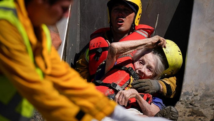 Firefighters and emergency medical personnel transport a resident, who had been trapped overnight in a care home, to an ambulance following Tropical Storm Hilary in Cathedral City, California, U.S., August 21, 2023. REUTERS/Bryan Woolston