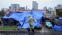 Para tunawisma menggunakan terpal plastik untuk melindungi diri dan barang-barang mereka dari hujan ringan yang dibawa Badai Tropis Hilary di pusat kota San Diego, Minggu (20/8/2023). Para peramal cuaca mengatakan Hilary adalah badai tropis pertama yang melanda California Selatan dalam 84 tahun terakhir, dan telah ditetapkan sebagai rekor terbasah dalam sejarah.