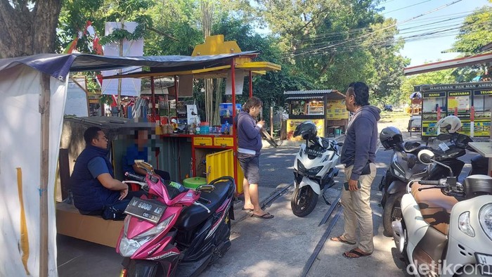 Polisi saat mendatangi salah satu pegawai kedai teh di Gresik.