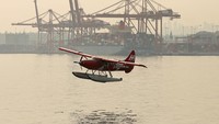 Sebuah pesawat apung lepas landas di Pelabuhan Vancouver, yang diselimuti asap kebakaran hutan.  