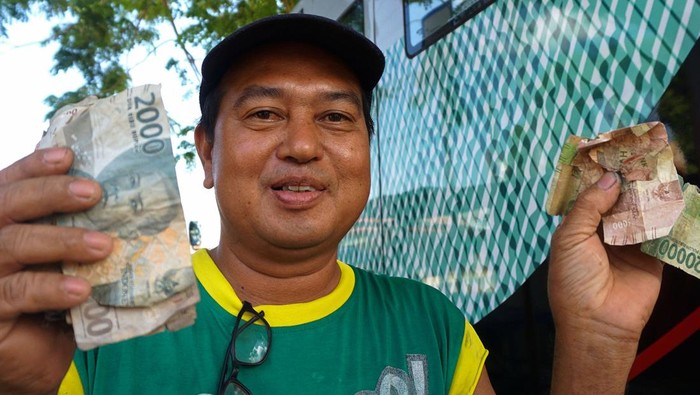 Warga menunjukkan uang yang baru ditukarkan di mobil kas keliling Kantor Perwakilan (KPw) Bank Indonesia (BI) Provinsi Gorontalo di Pasar Tapa, Kabupaten Bone Bolango, Gorontalo, Selasa (22/8/2023). BI Provinsi Gorontalo membuka pelayanan penukaran uang lusuh, rusak atau tidak layak edar dengan menyiapkan uang kartal sebesar Rp150 juta yang dapat ditukarkan masyarakat dengan mendaftar melalui aplikasi. ANTARA FOTO/Adiwinata Solihin/Spt.