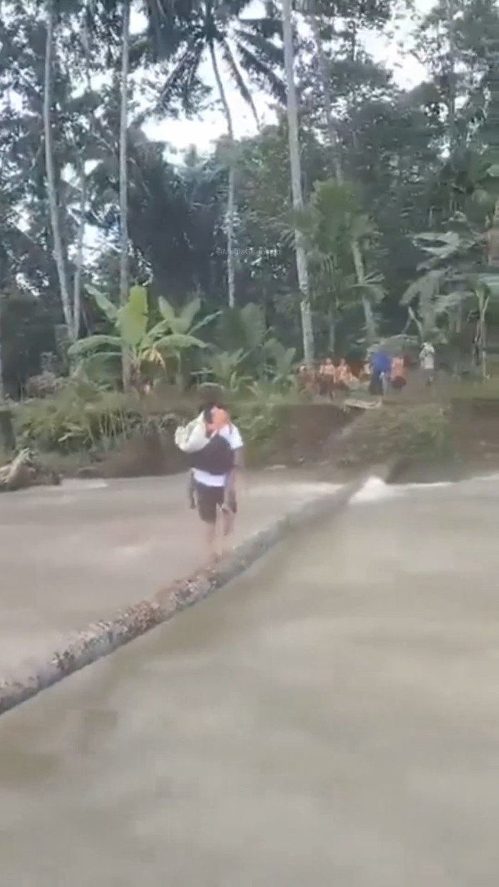 siswa SD di Nias Selatan nyeberang sungai pakai batang kayu. (Foto: Tangkapan layar)