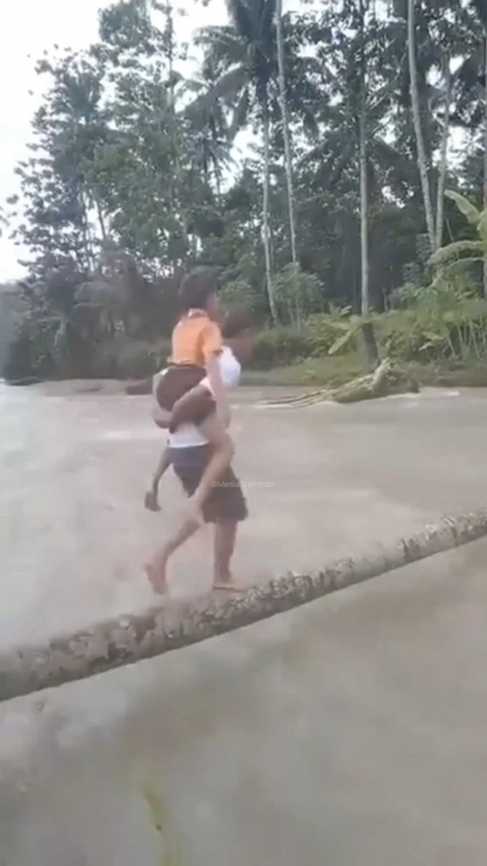 siswa SD di Nias Selatan nyeberang sungai pakai batang kayu. (Foto: Tangkapan layar) siswa SD di Nias Selatan nyeberang sungai pakai batang kayu. (Foto: Tangkapan layar)