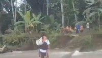 Saat kejadian itu, anak-anak tersebut dibantu oleh pemuda setempat untuk menyeberangi sungai.  (Foto: Tangkapan layar)