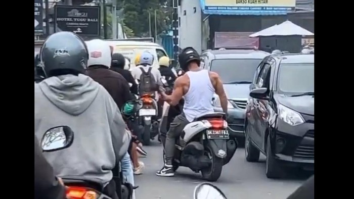 Tangkapan layar video viral bule angkat barbel di tengah jalan di Bali.
