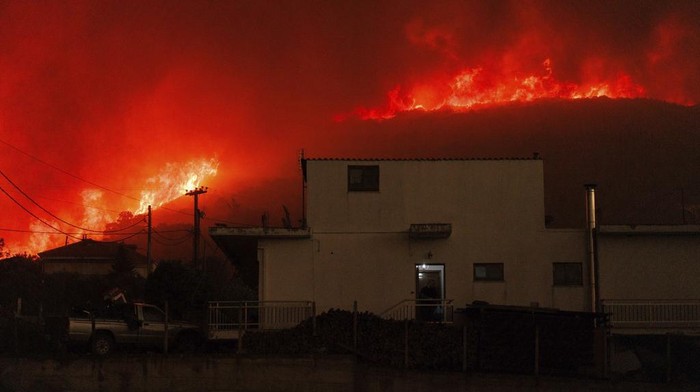 Was-was Warga Yunani Terkepung Kebakaran Hutan A local resident watches the wildfire in Avantas village, near Alexandroupolis town, in the northeastern Evros region, Greece, Monday, Aug. 21, 2023. Gale-force winds are fanning the flames of wildfires across Greece, including 53 new blazes that broke out early Monday amid hot, dry and windy weather that has sucked moisture from vegetation. (AP Photo/Achilleas Chiras)