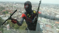 Pekerja berkostum Spiderman membersihkan kaca di Hotel Aria Gajayana, Malang, Jawa Timur, Rabu (23/8/2023). 