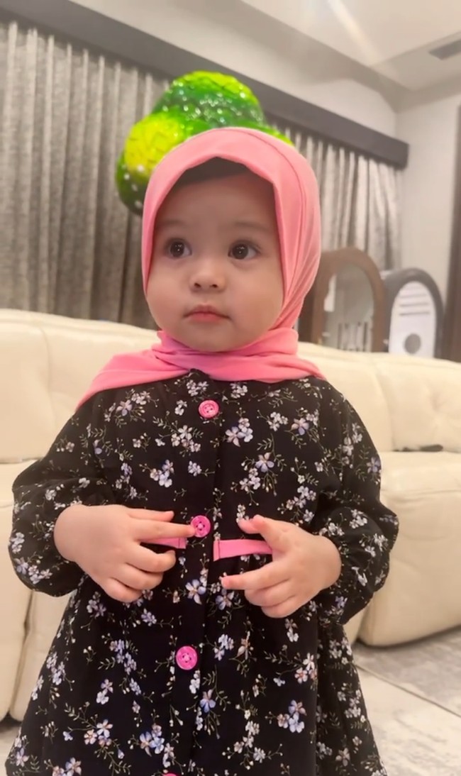 Ketika memakai hijab bergo, membuat pipi Ameena semakin bulat dan menggemaskan seperti boneka. Ameena mengenakan baju hitam motif bunga-bunga. Foto: Dok. Instagram @aurelie.hermansyah.