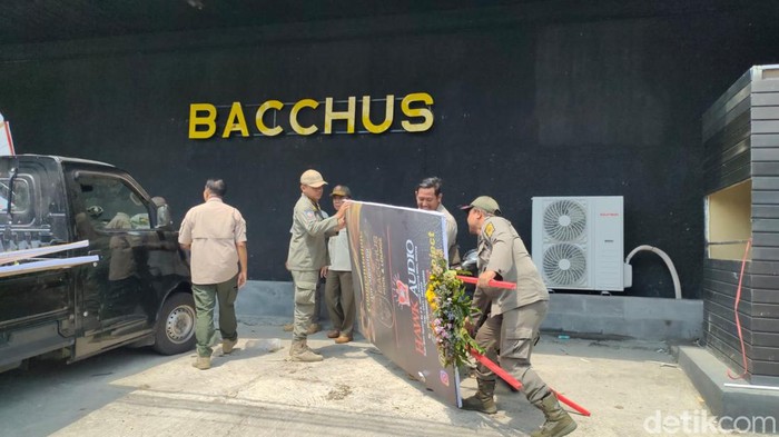 Anggota Satpol PP Kota Kediri sita karangan bunga ucapan selamat di kafe yang belum lengkapi izin.