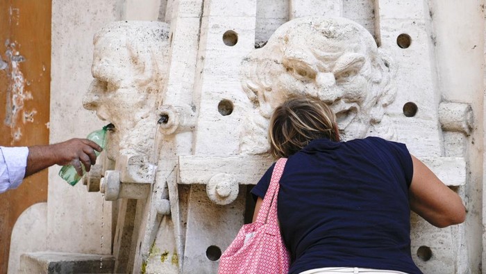 A man cools off at the Spanish Steps Barcaccia fountain in Rome, Tuesday, Aug. 22, 2023. Italy is facing a heat wave with temperatures in the capital as high as 37 Celsius (98 Farenheit). (AP Photo/Gregorio Borgia)