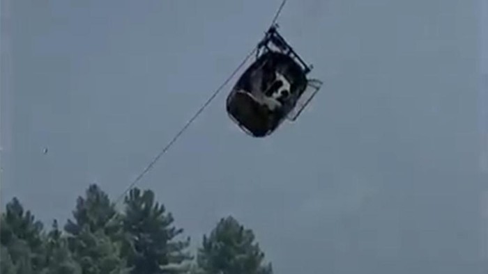 In this image taken from video, a cable car carrying six children and two adults dangles hundreds of meters above the ground in the remote Battagram district, Khyber Pakhtunkhwa, Pakistan on Tuesday, Aug. 22, 2023. The cable car malfunctioned, trapping the occupants for hours before rescuers arrived in helicopters to try to free them. (AP Photo)