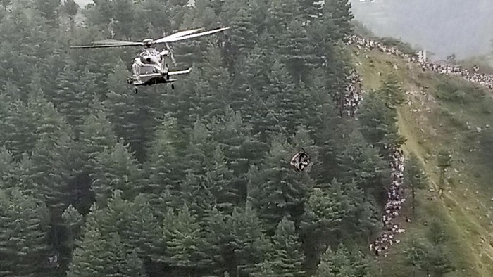 In this image taken from video, a cable car carrying six children and two adults dangles hundreds of meters above the ground in the remote Battagram district, Khyber Pakhtunkhwa, Pakistan on Tuesday, Aug. 22, 2023. The cable car malfunctioned, trapping the occupants for hours before rescuers arrived in helicopters to try to free them. (AP Photo)