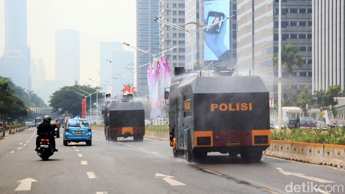 Kendaraan water cannon Brimob Polda Metro Jaya menyemprotkan air di Jalan Sudirman-Thamrin, Jakarta, Rabu (23/8/2023). Pemerintah Provinsi (Pemprov) DKI Jakarta dan Polda Metro Jaya melakukan penyemprotan air di sepanjang Jalan Medan Merdeka Barat hingga Patung Pemuda Membangun Senayan sebagai upaya untuk mengurangi polusi udara dan mengatasi cuaca panas di Ibu Kota.