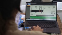 Petugas mengecek kadar gas buang sebuah kendaraan.  