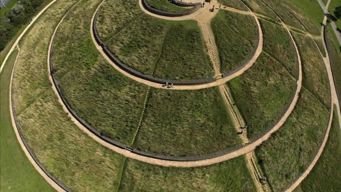 Potret Taman Pedesaan di London yang Dibangun dari Limbah People walk on a mount at Northala Fields in London, Monday, Aug. 21, 2023. Northala fields is a country park that consists of ponds and four large earth mounds built using waste from the original Wembley Stadium and the building of the White City Westfield shopping centre, reducing noise pollution, provide a view point and are an interesting landmark for the area in west London. (AP Photo/Frank Augstein)