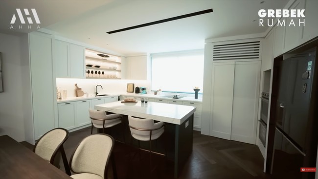 Lantai utama terdiri dari ruang keluarga, ruang makan, dapur. Semuanya menyatu tanpa sekat sehingga terasa lebih lapang. Warna putih yang mendominasi semakin menambah kelegaan tersebut. “Teman-temanku bilang jadi mirip apartemen,” kata ibu satu anak ini.   Foto: YouTube/AH