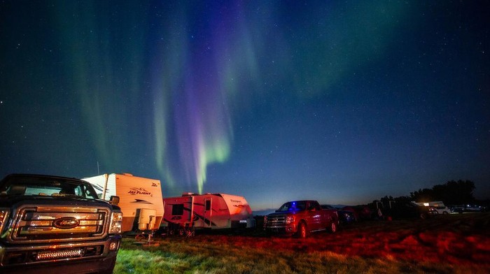 Evacuees from Yellowknife, territorial capital of the Northwest Territories, are greeted with the Aurora Borealis as they arrive to a free campsite provided by the community in High Level, Alta., Friday, Aug. 18, 2023.  (Jason Franson /The Canadian Press via AP)