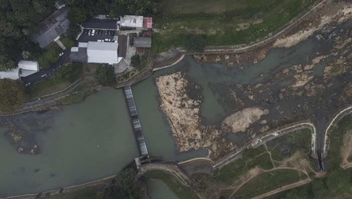 Foto udara kondisi aliran Sungai Citanduy surut di Bendungan Citanduy, Dobo, Kota Banjar, Jawa Barat, Kamis (24/8/2023). Memasuki musim kemarau, aliran Sungai Citanduy mulai surut dan mengakibatkan pasokan air untuk mengairi ribuan hektare lahan pertanian di wilayah Kota Banjar, Ciamis, dan Cilacap, Provinsi Jawa Tengah berkurang. ANTARA FOTO/Adeng Bustomi/rwa.