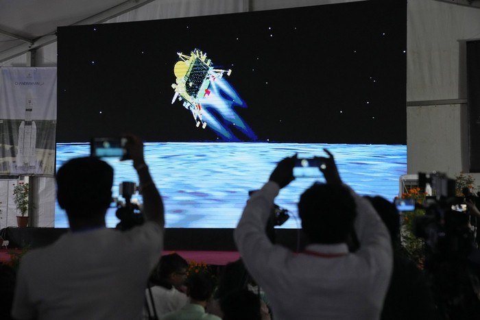Journalists film the live telecast of spacecraft Chandrayaan-3 landing on the moon at ISROs Telemetry, Tracking and Command Network facility in Bengaluru, India, Wednesday, Aug. 23, 2023. India lands a spacecraft near the moon’s south pole, becoming the fourth country to touch down on the lunar surface. (AP Photo/Aijaz Rahi)