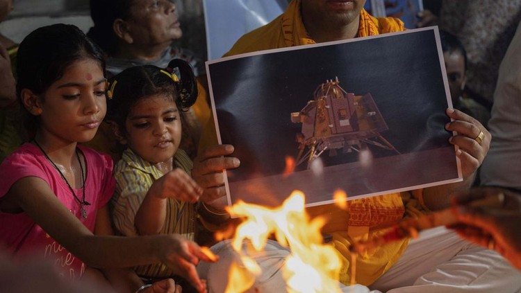 Momen Roket India Mendarat di Bulan Arun Haryani, an enthusiast with his body painted in tri-colours reacts as he holds up a model of LVM3 M4 which was used in launching of Chandrayaan-3 spacecraft on the eve of its moon landing, in Ahmedabad, India, August 22, 2023. REUTERS/Amit Dave TPX IMAGES OF THE DAY