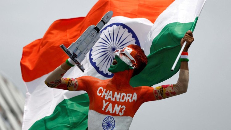 Arun Haryani, an enthusiast with his body painted in tri-colours reacts as he holds up a model of LVM3 M4 which was used in launching of Chandrayaan-3 spacecraft on the eve of its moon landing, in Ahmedabad, India, August 22, 2023. REUTERS/Amit Dave     TPX IMAGES OF THE DAY