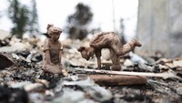 Dua buah patung berdiri di puing-puing rumah yang terbakar di British Columbia, Kanada.  