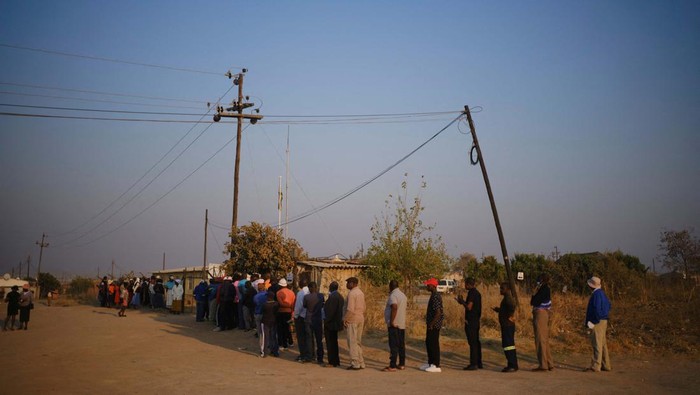 Pemilu di Tengah Kemiskinan, Warga Zimbabwe Antre di TPS Voters wait in a queue to cast their ballots at a polling station in Cowdray Park as the Zimbabwean harmonised elections got off to a late start in Bulawayo, Zimbabwe, August 23, 2023. REUTERS/KB Mpofu