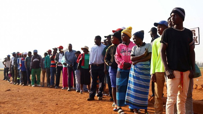 Pemilu di Tengah Kemiskinan, Warga Zimbabwe Antre di TPS Voters wait in a queue to cast their ballots at a polling station in Cowdray Park as the Zimbabwean harmonised elections got off to a late start in Bulawayo, Zimbabwe, August 23, 2023. REUTERS/KB Mpofu