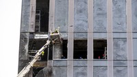 Para pekerja membersihkan bagian gedung pencakar langit yang rusak setelah serangan drone. Kementerian Pertahanan Rusia menyebut pasukan pertahanan udara di dekat Moskow berhasil menembak jatuh dua drone di atas wilayah distrik Mozhaisky dan Khimki.