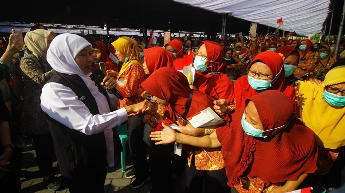 Penyerahan BLT buruh pabrik rokok Gubernur Jawa Timur Khofifah Indar Parawansa (tengah) membawa Bendera Merah Putih didampingi Direktur PT HM Sampoerna Tbk Elvira Lianita (kanan) di sela penyerahan Bantuan Langsung Tunai (BLT) di Surabaya, Jawa Timur, Kamis (24/8/2023). Sebanyak 9.259 pekerja pabrik rokok di Jawa Timur mendapat BLT Provinsi masing-masing sebesar Rp1,5 juta yang berasal dari Dana Bagi Hasil Cukai dan Hasil Tembakau (DBHCHT). ANTARA FOTO/Moch Asim/nym.